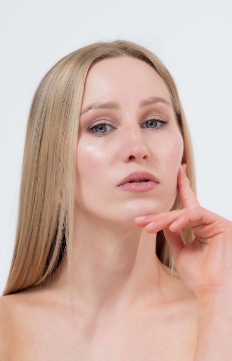 Porträt einer jungen Frau mit langen, blonden Haaren, nachdenklichem Ausdruck.