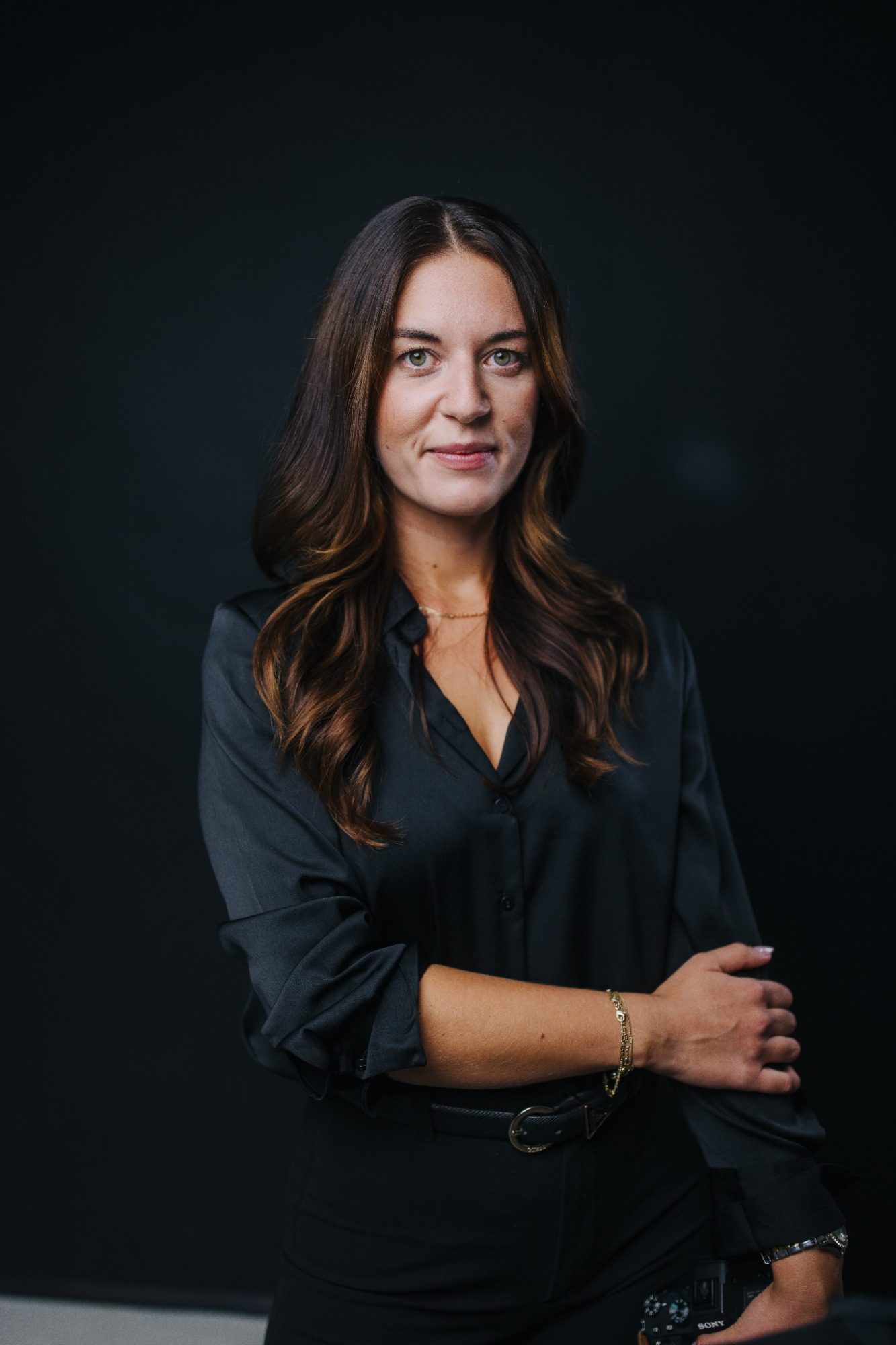 Zwei Frauen lachen und unterhalten sich, während eine Kamera in der Hand gehalten wird.