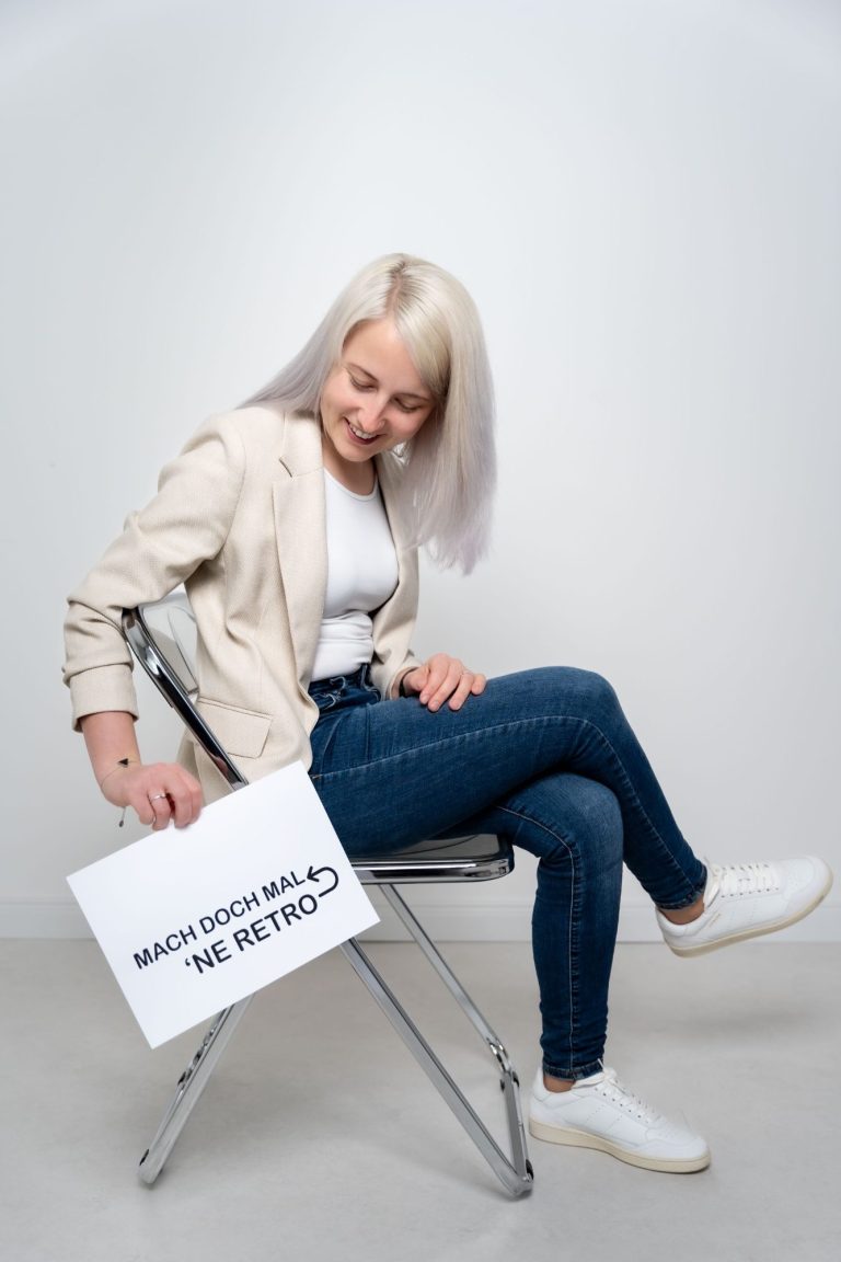 Junge Frau mit Notizbuch spricht lächelnd mit einem Mann. Farbhintergrund.