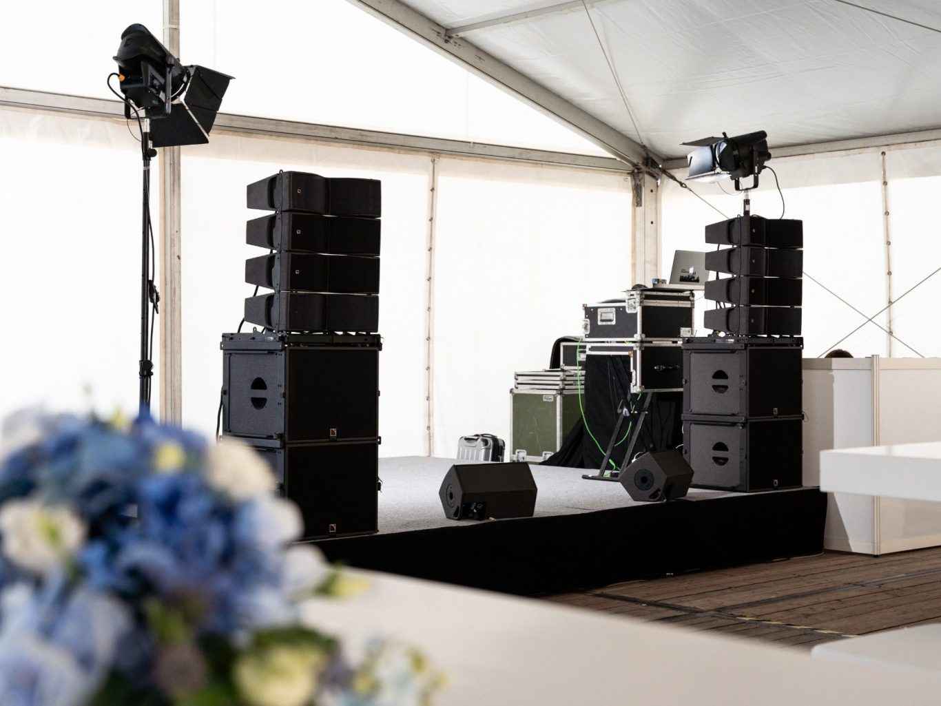 Bühne mit Lautsprechern, Mischpult und Beleuchtung in einem Zelt.